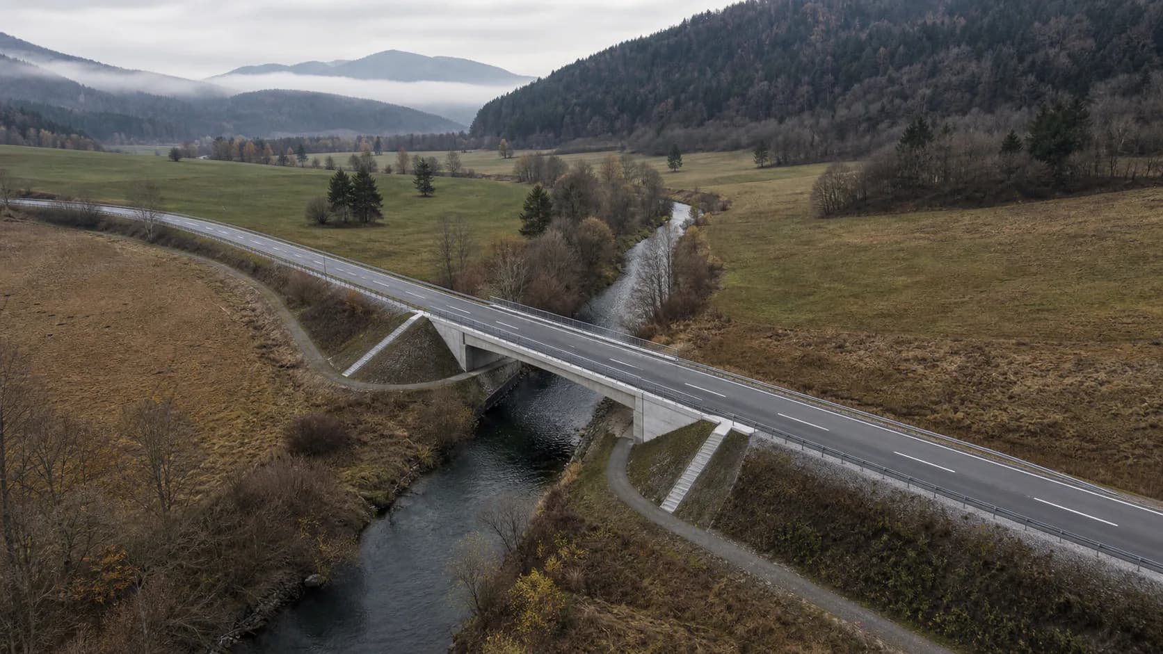 Ilustrativni zračni pogled na most in cesto v anonimni alpski dolini